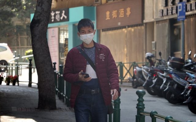 a man walking with a surgical mask on